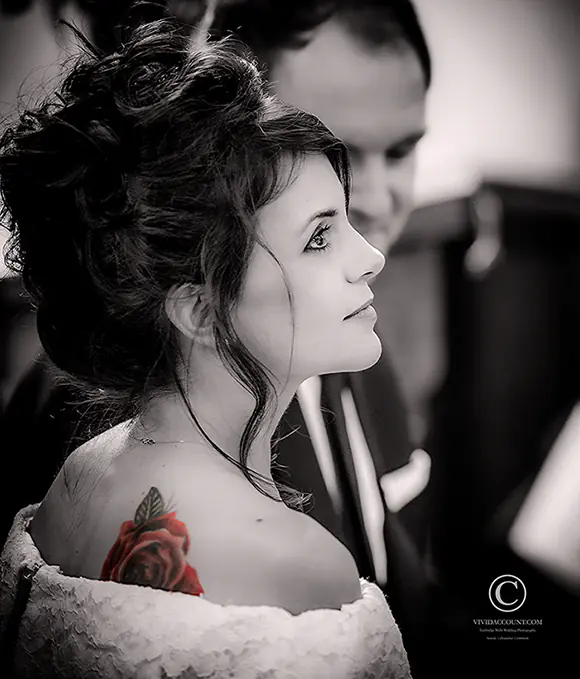 red rose tattoo on bride's shoulder visible from the hem of wedding dress