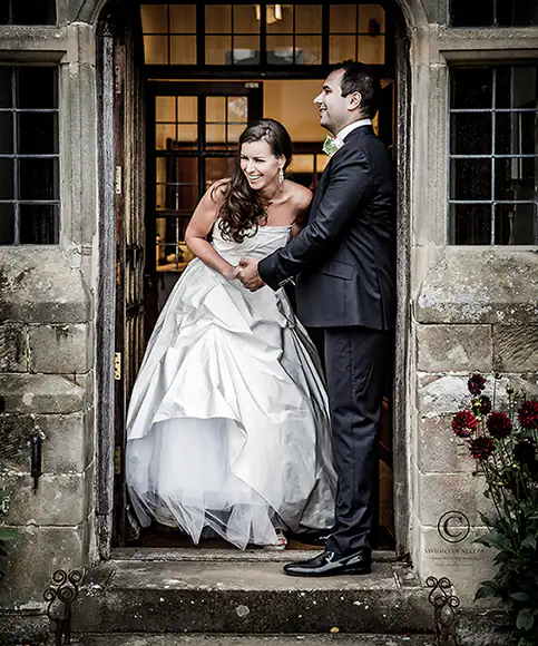bride and groom caught kissing in the doorway of their Tunbridge Wells home