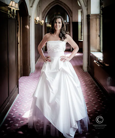 standing in a corridor at Ashdown Park Hotel near Tunbridge Wells, bride shows off her designer wedding dress ahead of her wedding ceremony