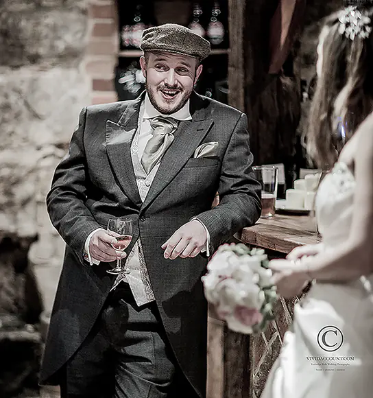 best man has a drink at the bar of a Tunbridge Wells wedding venue whilst entertaining the bride and others