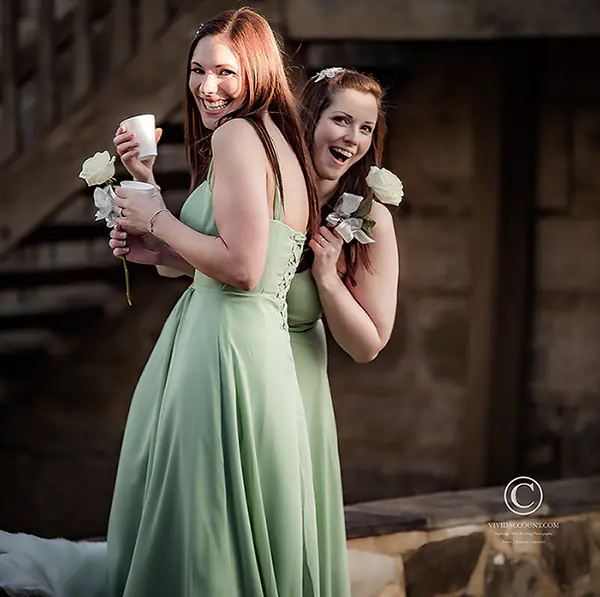 bridesmaids in green dresses giggling with mulled wine during wedding at Swallows Oast, Ticehurst near Tunbridge Wells