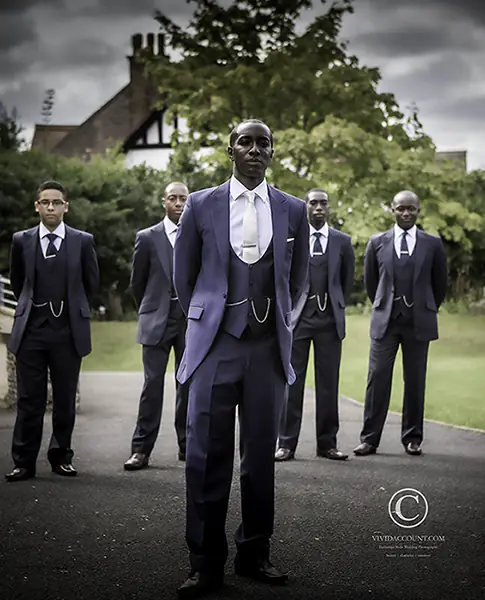 groom and groomsmen pose for stylised formal wedding group portrait outside church