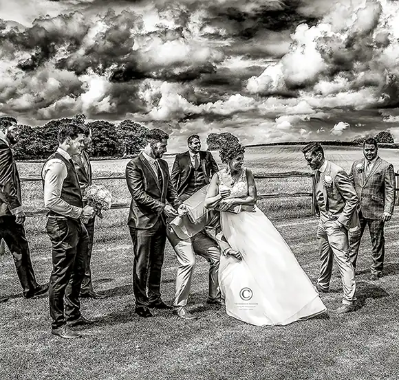 groomsmen teasing Tunbridge Wells bride and theeatening to carry her off from the field in their Tunbridge Wells wedding venue