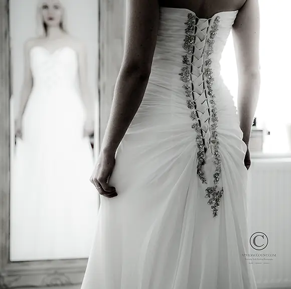 back of jewelled wedding dress from Tunbridge Wells as brides gives herself one last check in the bedroom mirror before leaving for wedding