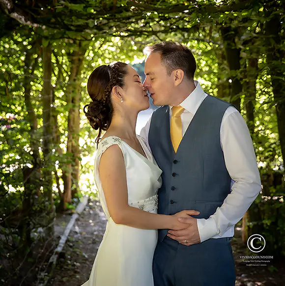 Wedding kiss under the shade of grape vines
