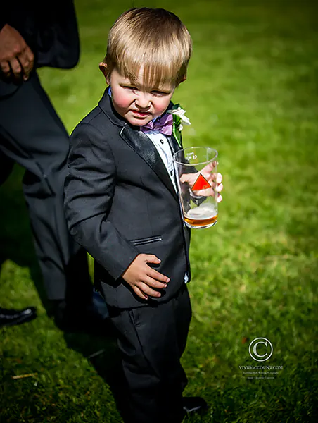 pageboy in Tunbridge Wells wedding Tuxedo holds his dads pint