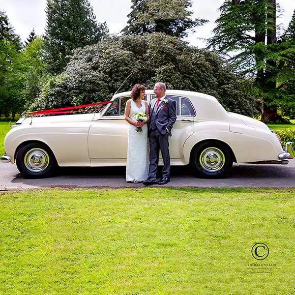 bride and groom standing together on their drive in front of their Tunbridge Wells wedding Rolls Royce car
