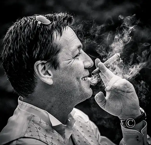 groom smoke celebratory cigar during his wedding reception at Salomons Estate, Tunbridge Wells