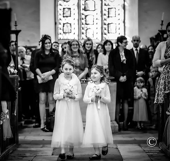 two young bridesmaids lead the procession into a Tunbridge Wells church to commence the wedding service