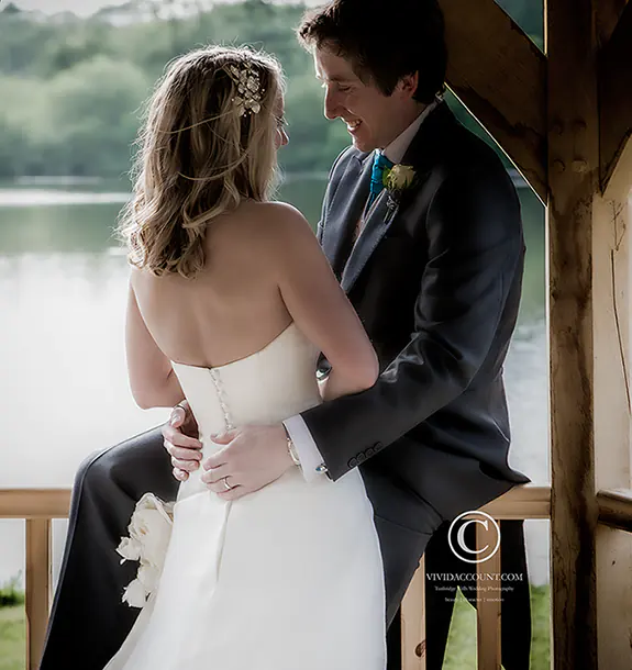 newly married husband and wife relax together in front of the lake at their wedding venue near Tunbridge Wells
