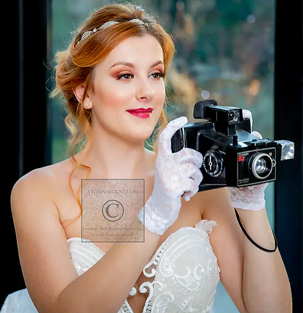 Bride takes photos of her antique wedding reception in Tunbridge Wells using a classic old polaroid camera